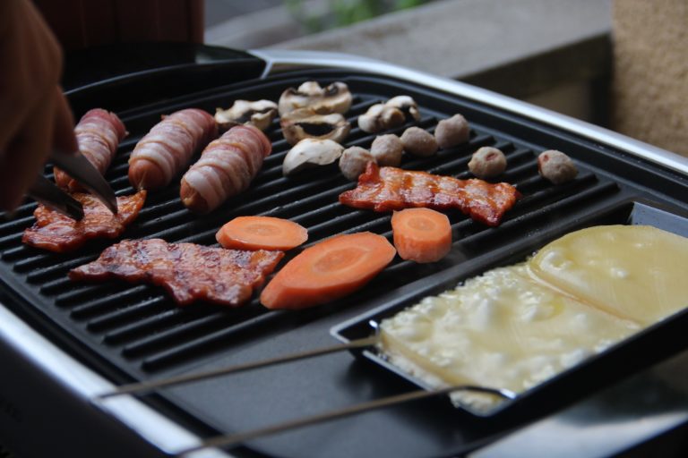 a raclette grill with some meat and vegetables on it