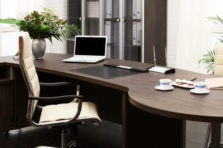 a large office desk with a laptop and other supplies on it