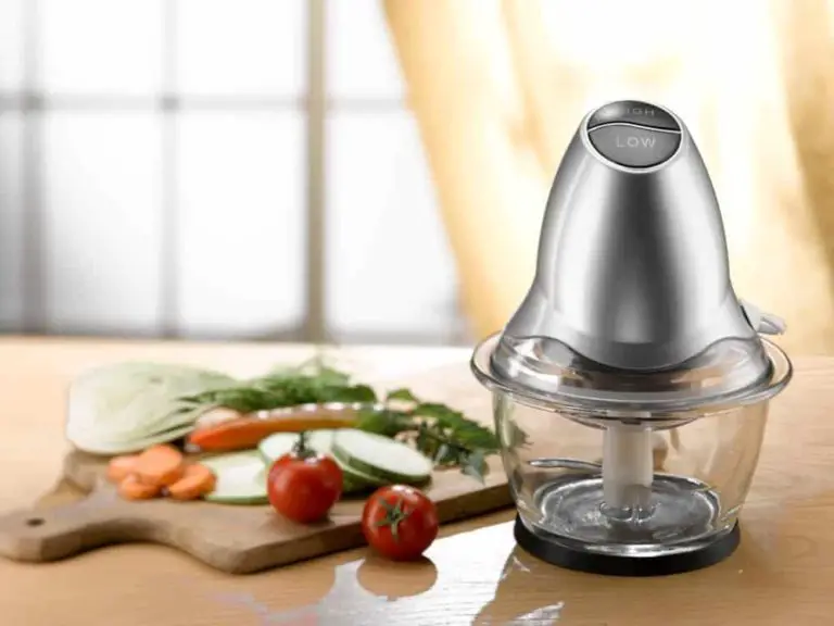 a mini food processor sits next to some assorted vegetables