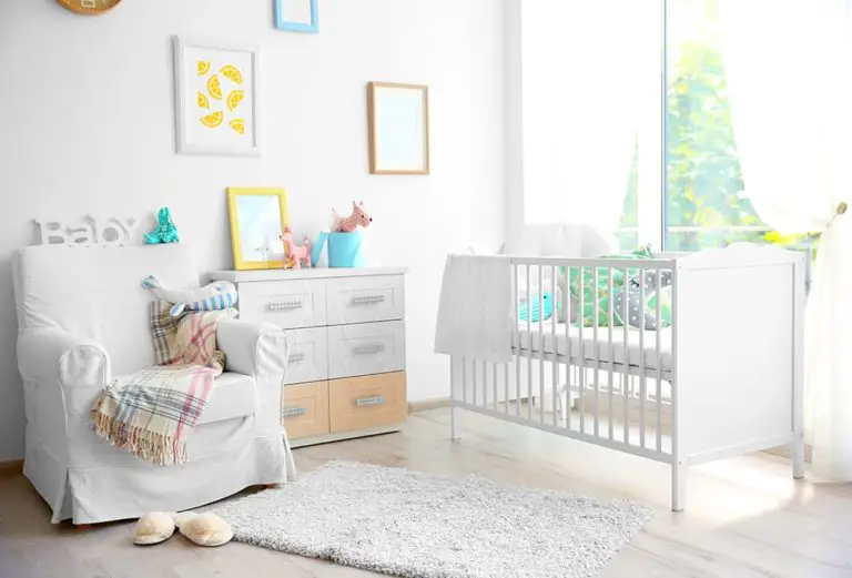 a nursery recliner resides within a nursery next to a dresser and crib