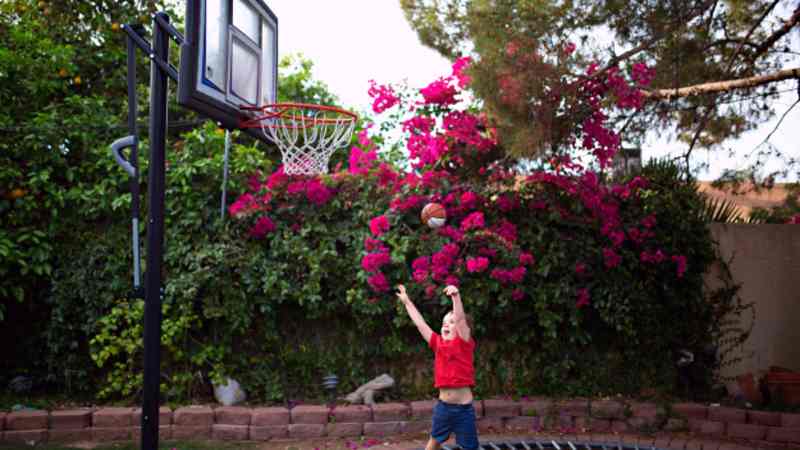 Boy shooting ball from trampoline