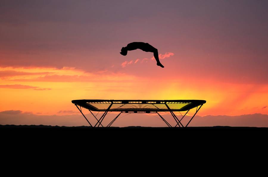 Backflip on trampoline at sunset