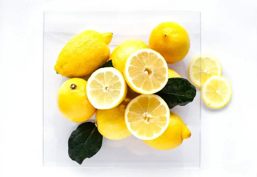 A bowl filled with lemons and lemon halves