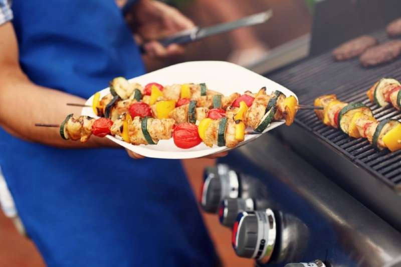 Cheff holding a plate full of grilled food 