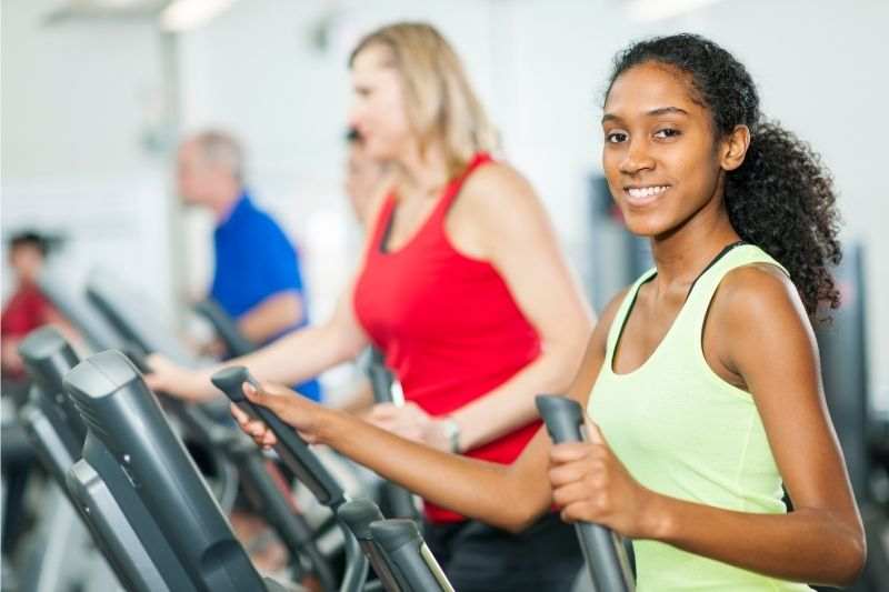 A young woman exercising on an elliptical cross trainer 