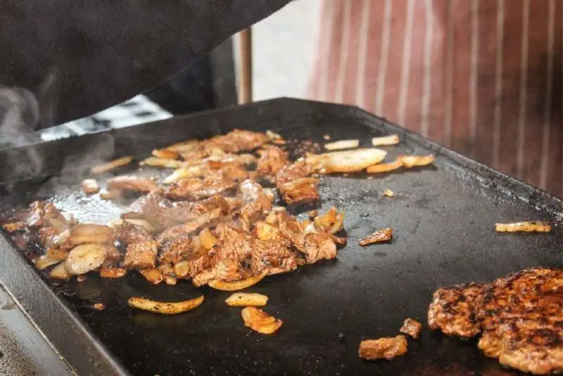 Grilled meat and veggies on a griddle surface 