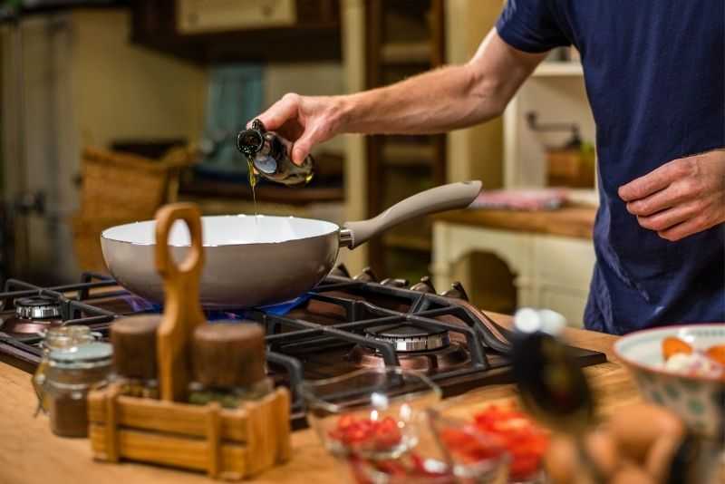 A man cooking on a professional gas range at home