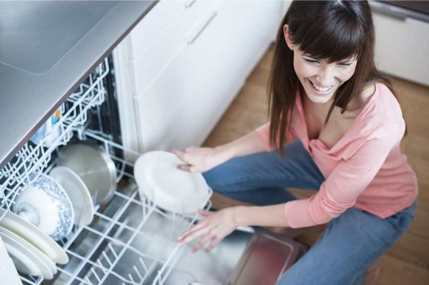 A woman clearing out the dishwasher