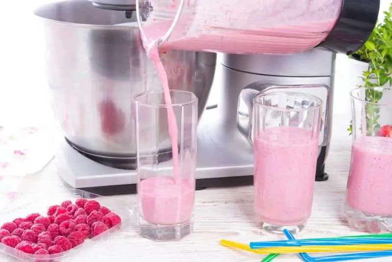 A fresh batch of raspberry juice being poured into glasses