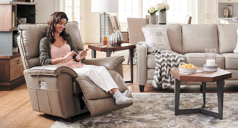 A woman charging her phone through a recliner