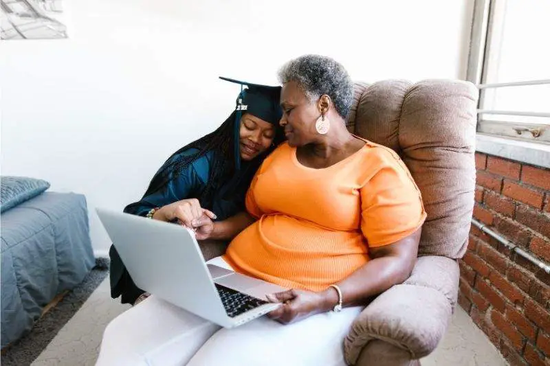 A senior woman and a young girl looking at a laptop