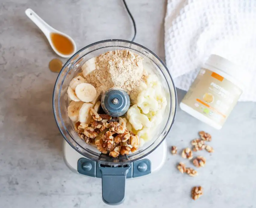 A Vitamix blender full of healthy fruits and nuts