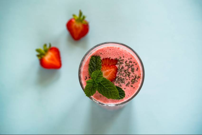 A top view of a strawberry smoothie with some mint