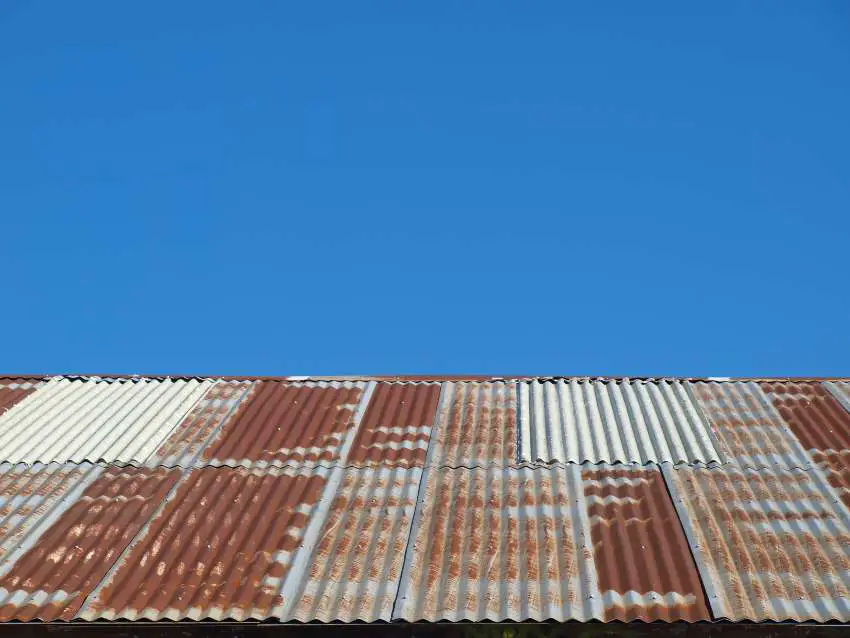 Rusty metal roofing against a bright blue sky