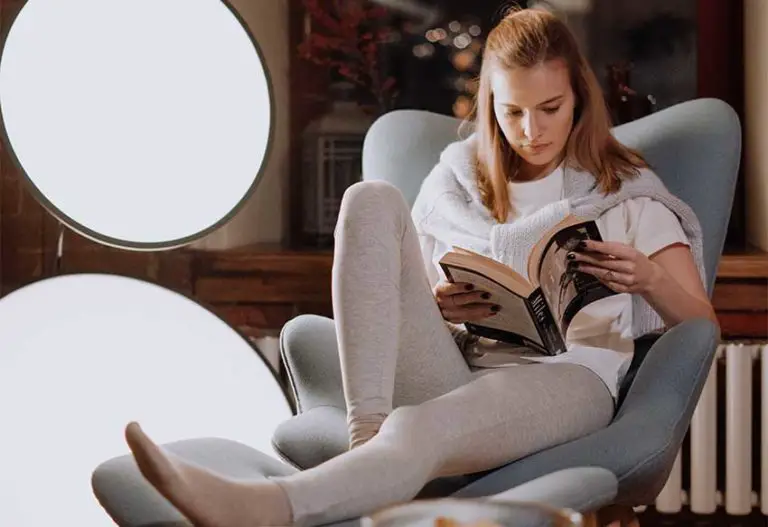 woman reads a book in a swivel recliner