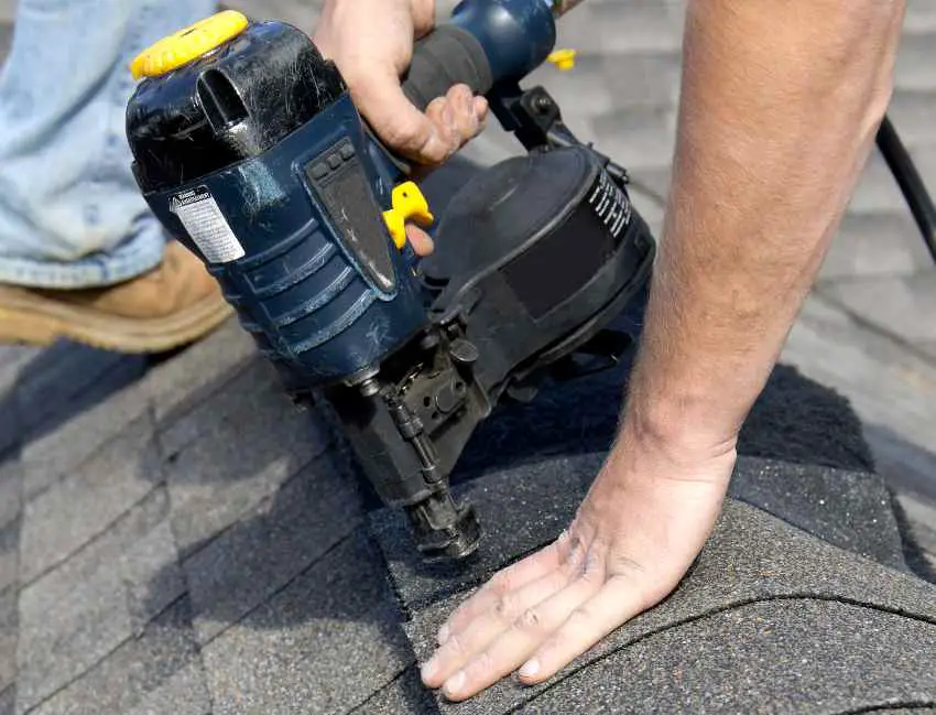 a person nailing shingles over a ridge 