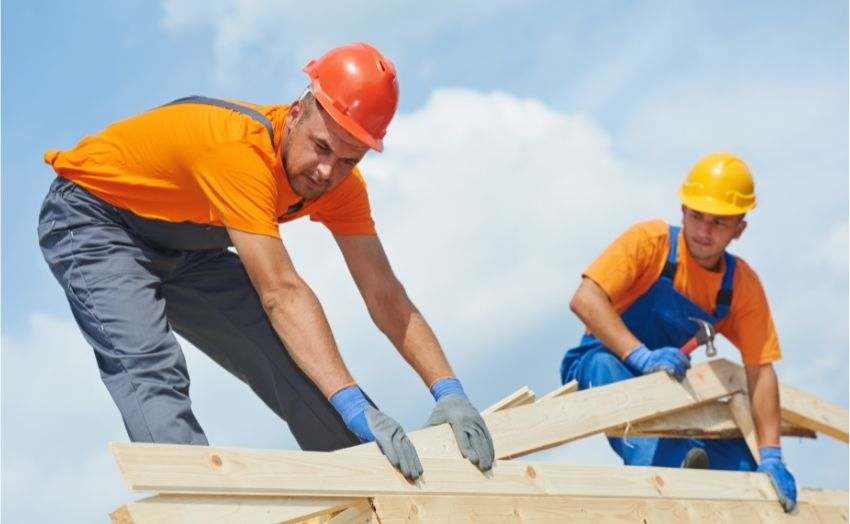 Two construction workers working on a new roof