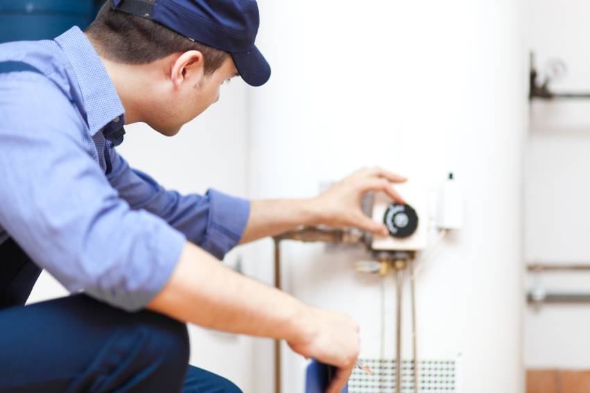 A plumber finishing water heater setup process