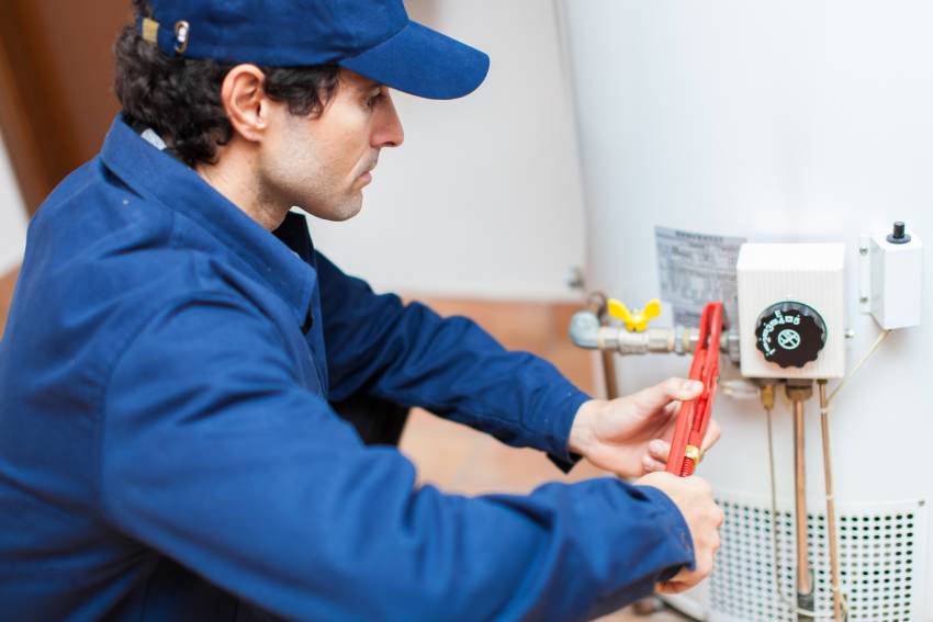 A plumber installing a water heater 