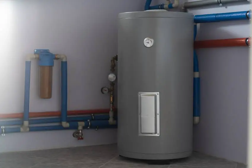 A gray indirect boiler in the corner of a room