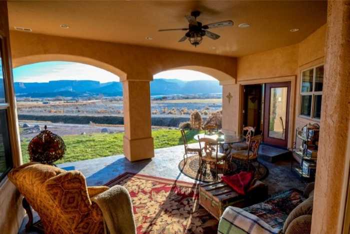 A 5-blade ceiling fan hanging from a patio ceiling 