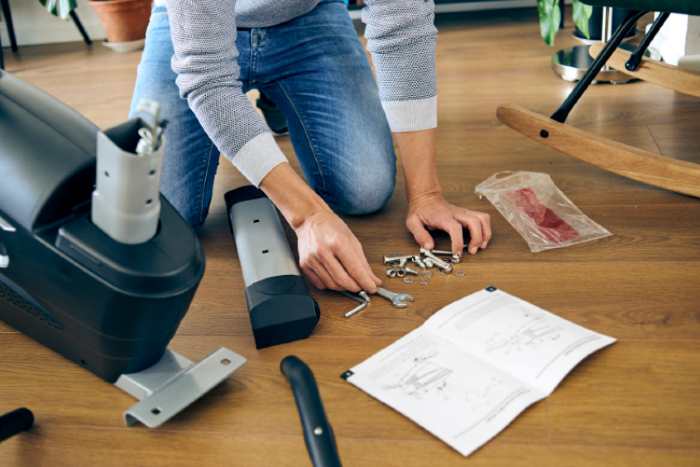 A person assembling a recumbent bike at home