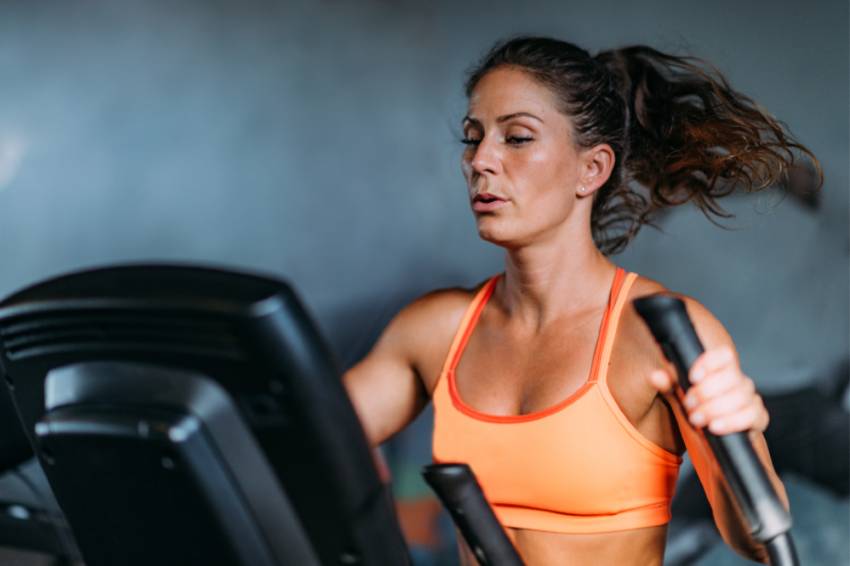 A strong woman working out on an elliptical 