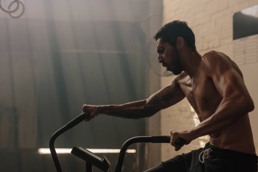 A man doing an intense air bike workout