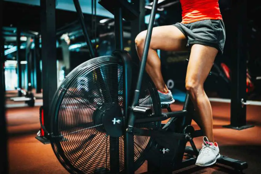 A close up of a woman exercising on an air bike