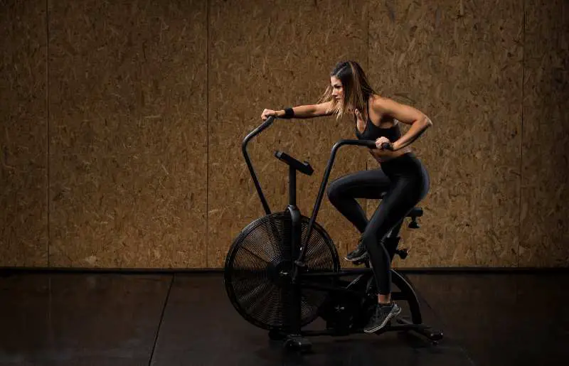 A strong woman exercising on an air bike