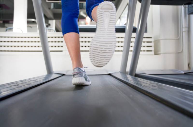 A picture of a young woman running on a treadmill