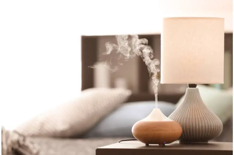 A humidifier next to a lamp on the night table 