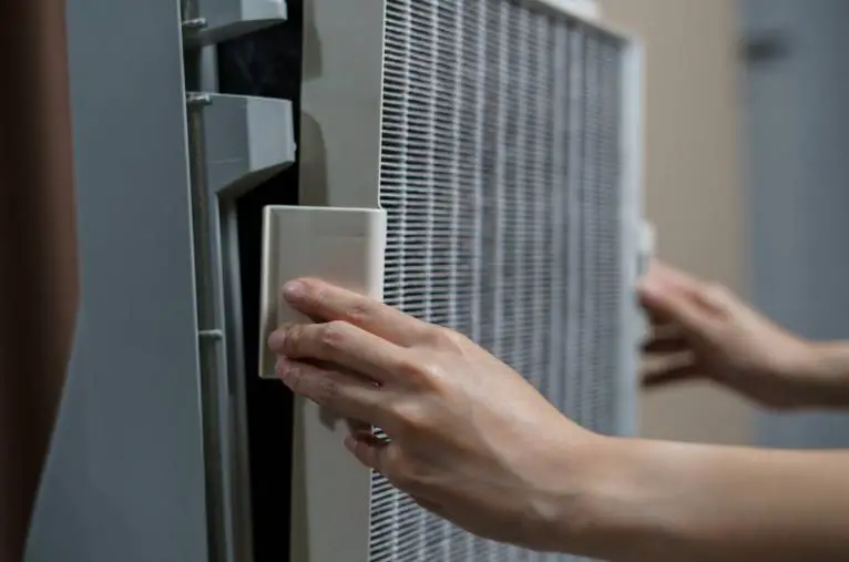 A person openning the HEPA filter holder 