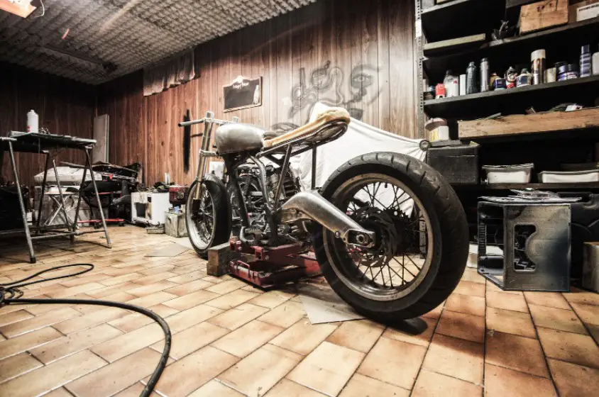 A motorcycle parked in a garage full of stored items and tools